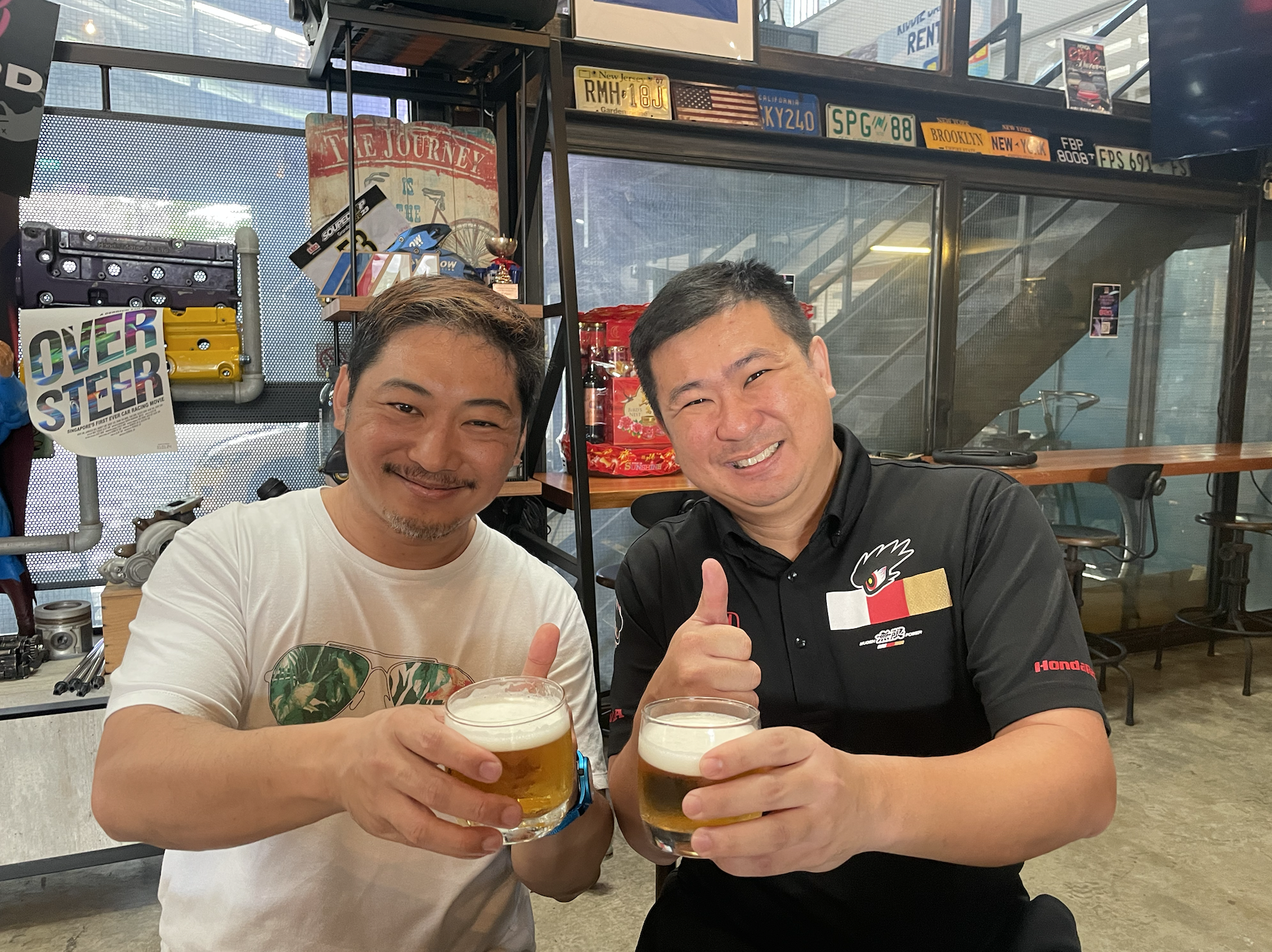 Derrick Lui and Ong Pang Yang cheers-ing beers with thumbs up at Roundings
